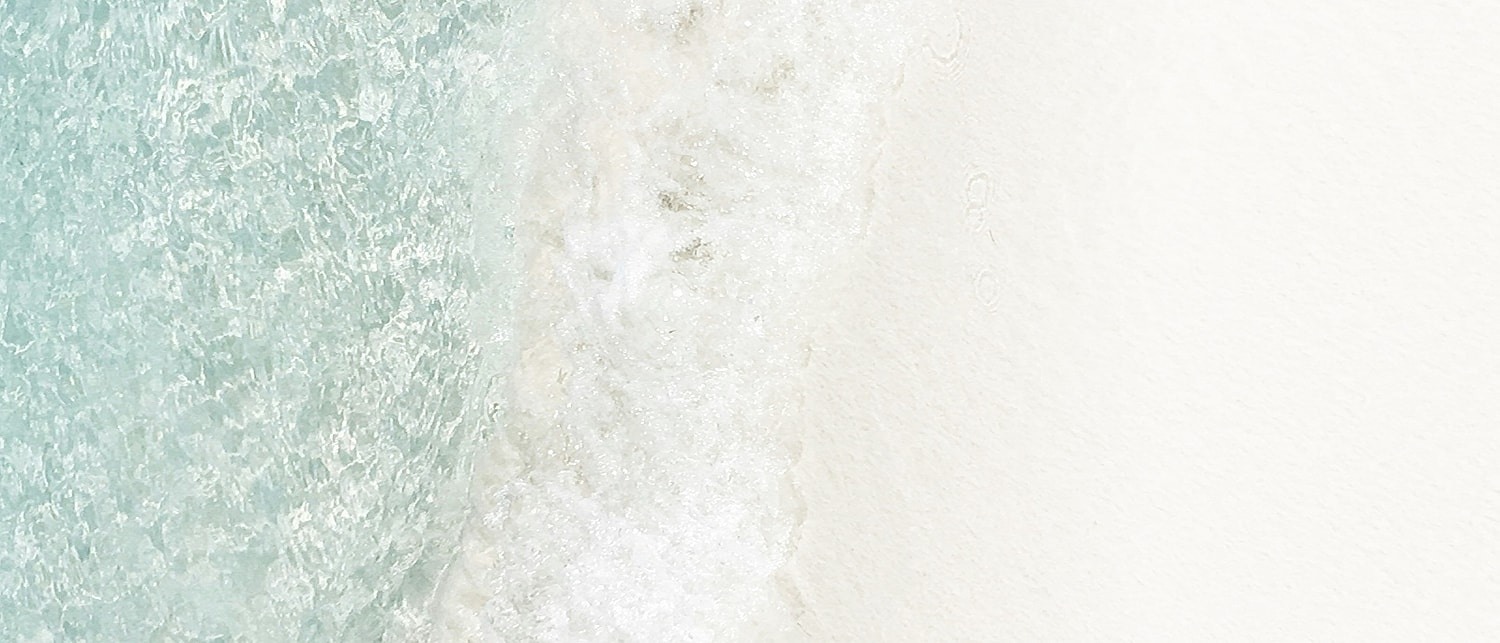 Waves gently lapping on a sandy beach.