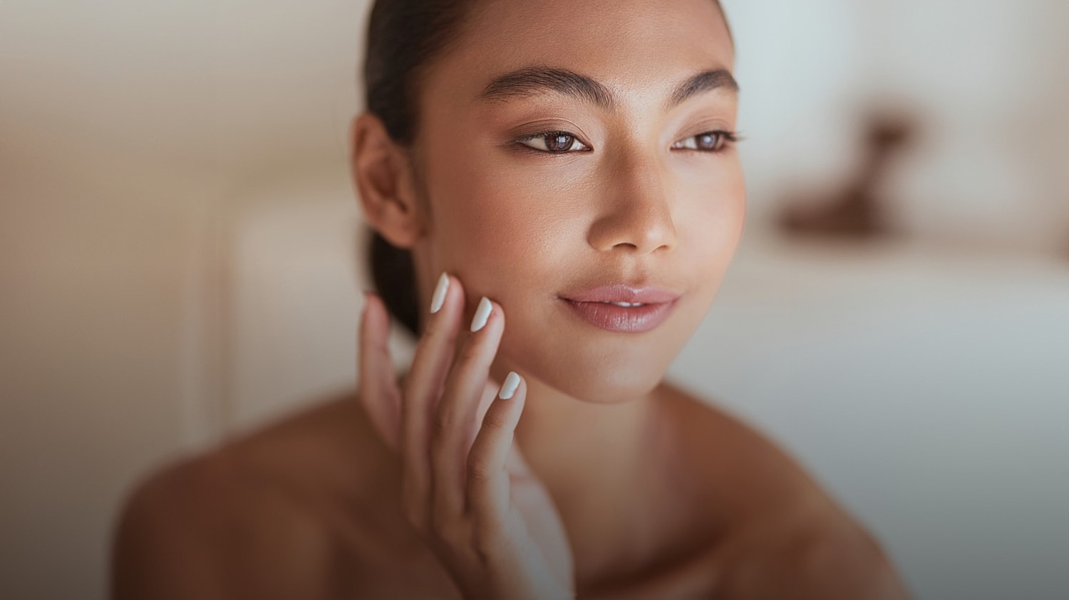 Woman gently touching her face, natural beauty.