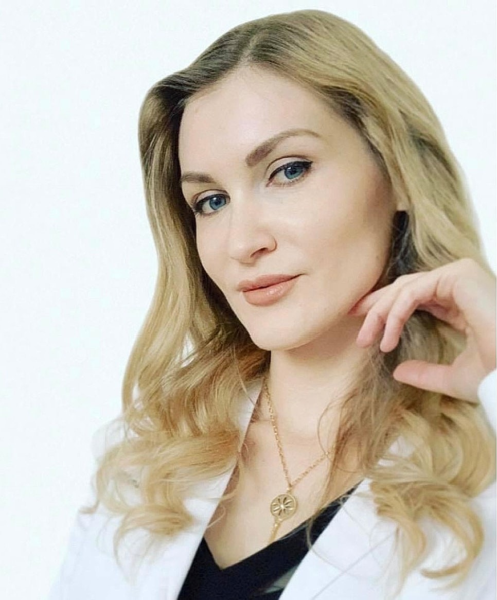 Woman with blonde hair posing thoughtfully.